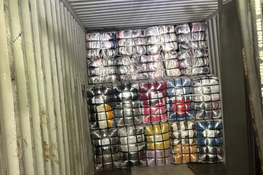 Clothing bales stacked at the back of a container during loading