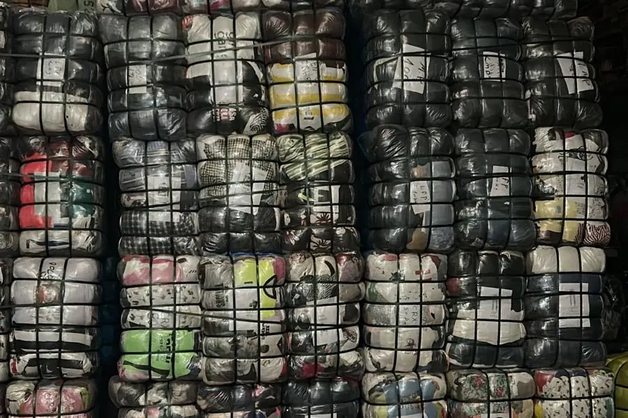 Pressed bales of second-hand clothing stacked in our warehouse