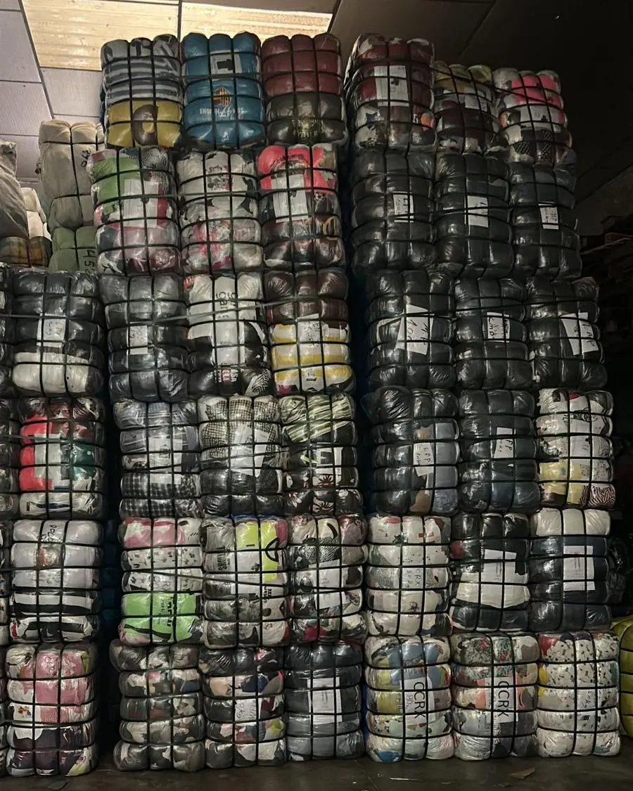 Pressed bales of second-hand clothing stacked in our warehouse
